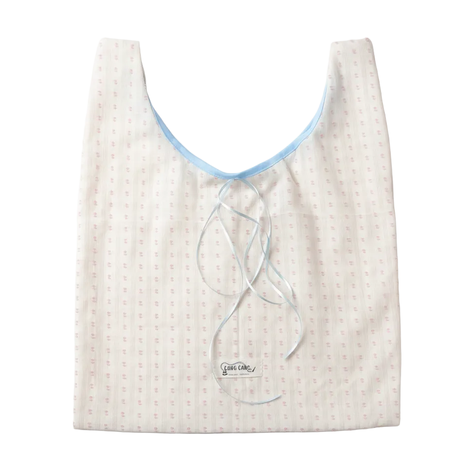 White with pink polka dots tote bag with blue ribbon, front view on white background