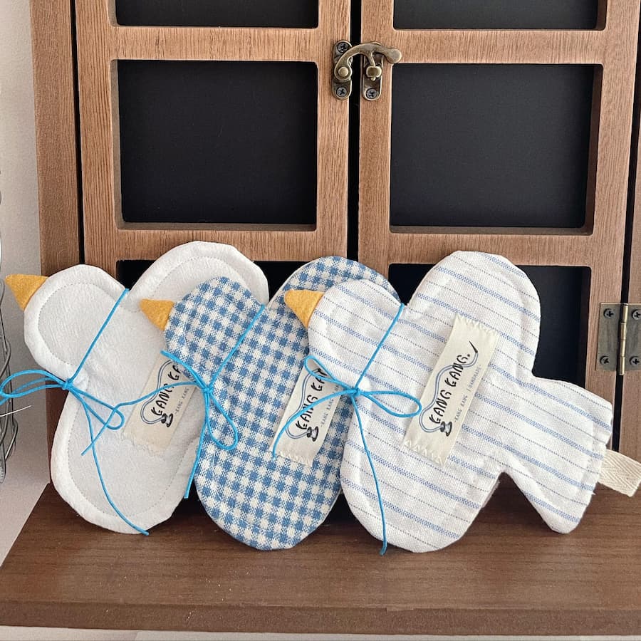 Three different bird-shaped coasters placed on a wooden table