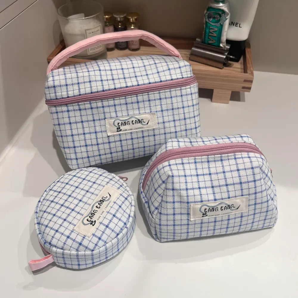Kang Kang Handmade 3-piece blue white plaid makeup bag set styled on bathroom vanity – box bag, trapezoid pouch, and round pouch